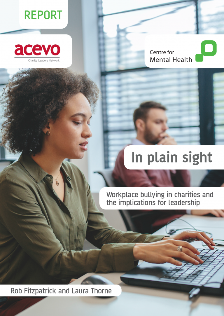 Cover of report Two people working on their laptops It reads: Report: In plain sight, by ACEVO and Centre for Mental Health Workplace bullying in charities and the implications for leadership Rob Fitzpatrick and Laura Thorne
