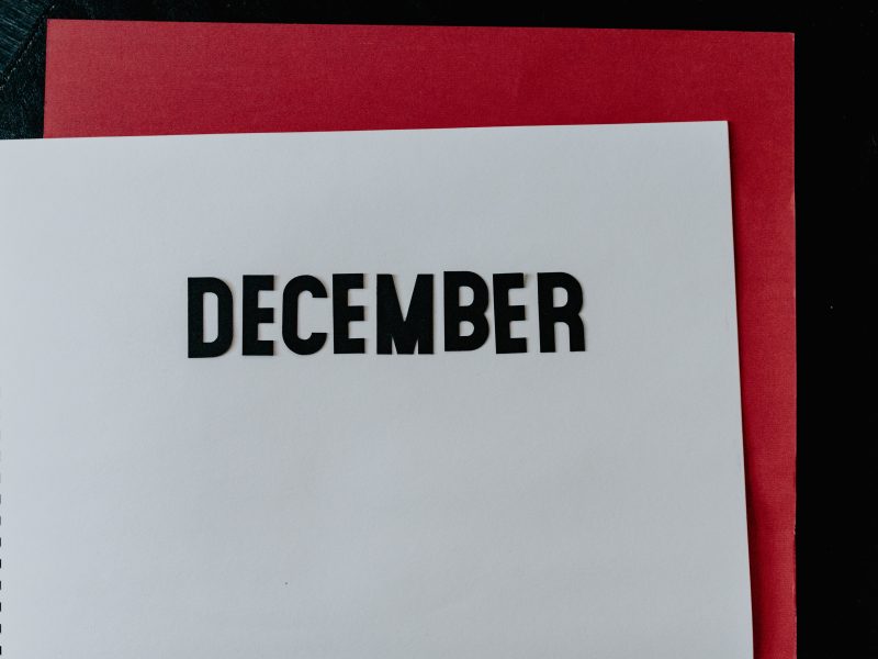 Notebook open in a blank page, the word December is written on it