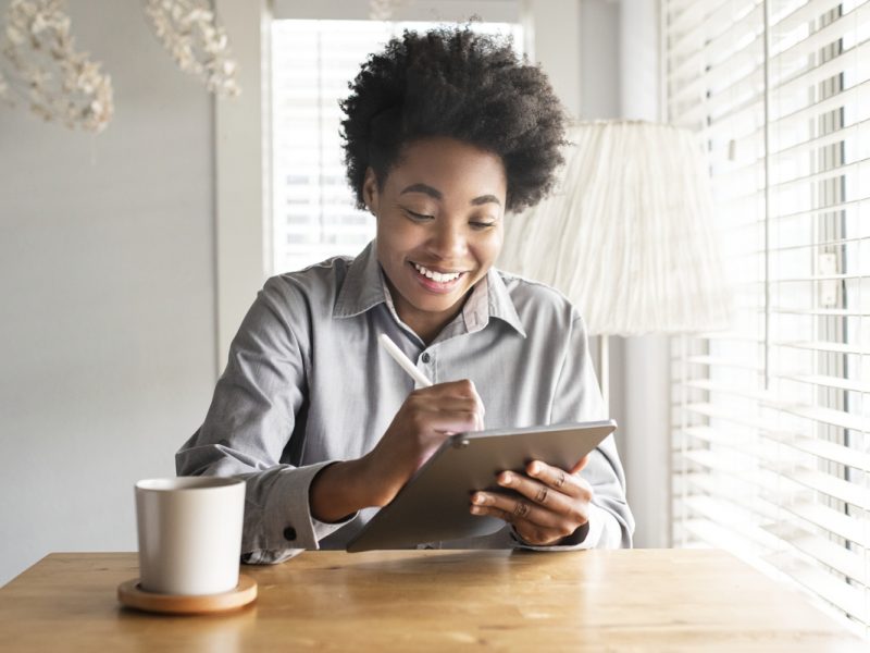 woman looking at a tablet, she is smiling.