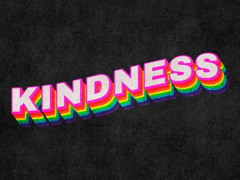 Kindness written in pink over a black background
