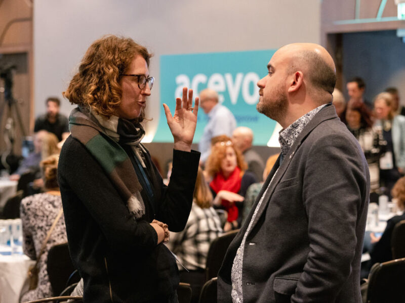 two people standing up, having a conversation