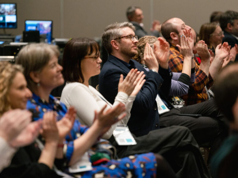 people sitting down and applauding