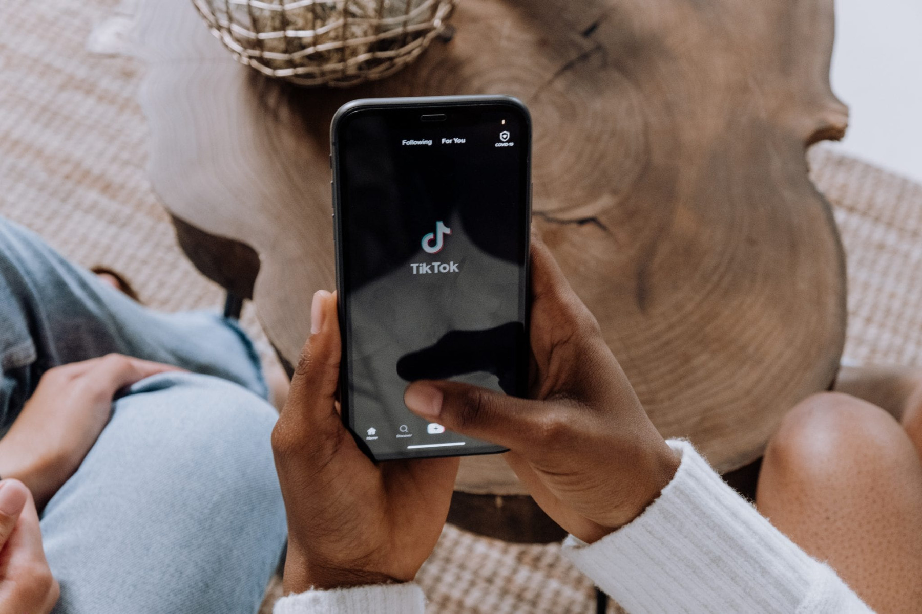 photo of a person holding a phone, opening the Tiktok app