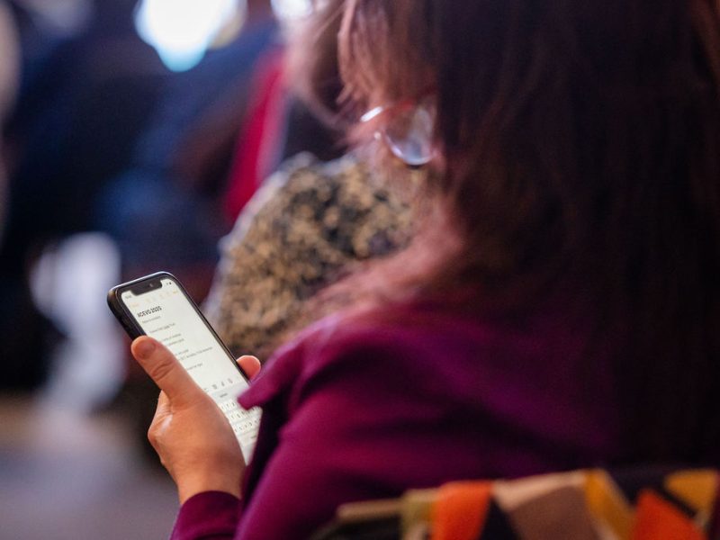 woman sitting down, she is checking her phone