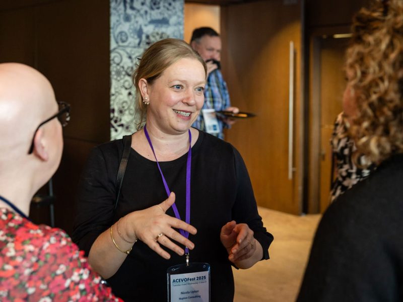 three people having a conversation, standing up.