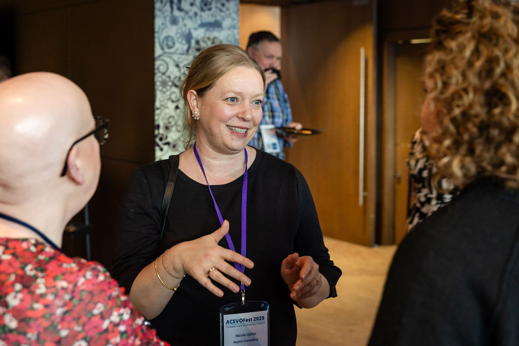 three people having a conversation, standing up.