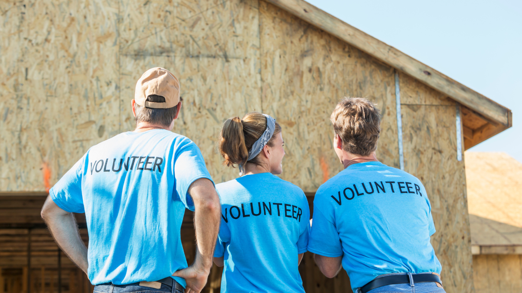 three people wearing a t shirt with the word 'volunteer' on their backs