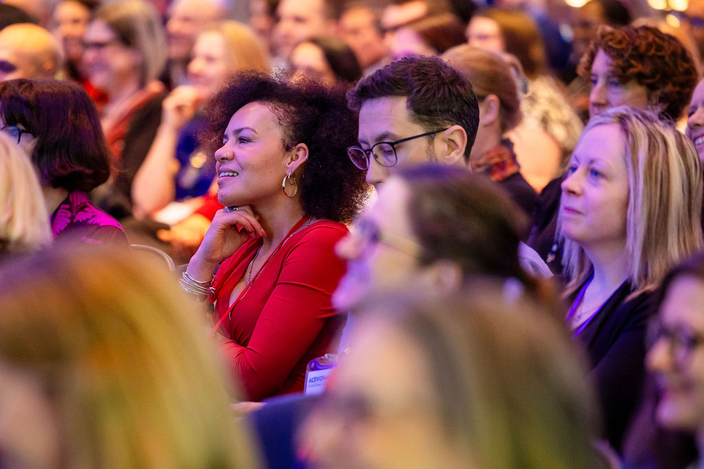 people attending a conference, sitting down and looking at the stage