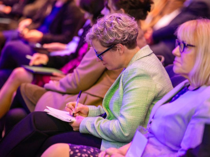 person attending a conference, taking notes