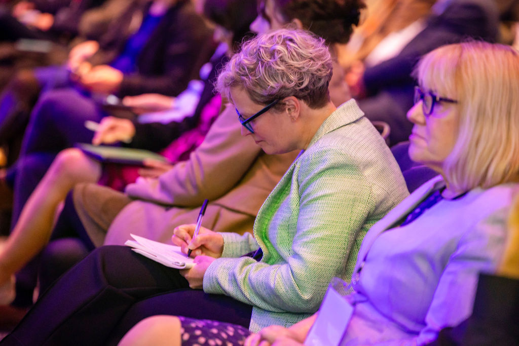 person attending a conference, taking notes